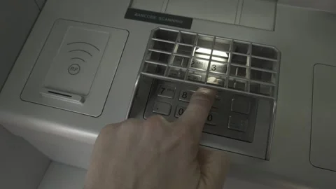 Entering a PIN code with your finger on the ATM keypad to withdraw money, close Stock Footage 307196357