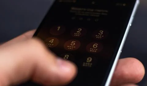 Entering a pin or secret code on a smartphone. The screen with the numbers of Stock Photos