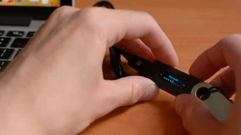 Entering secure PIN code on Ledger Nano cold hardware Bitcoin wallet and 库存影片 93942067