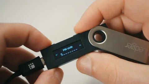 Entering secure PIN code on Ledger Nano S cold hardware Bitcoin wallet Stock Footage 100466465