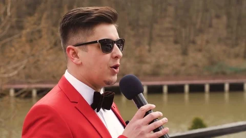 Entertainer Talking and guesturies with microphone Stock Footage 77559043