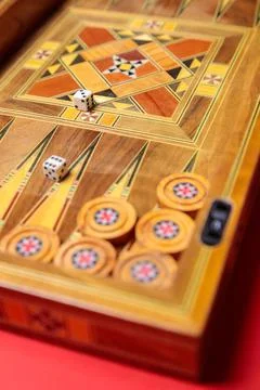 An entertaining backgammon game. Checkers, cubes, handmade board Stock Photos