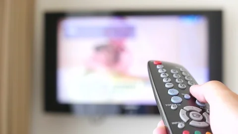 Entertainment- The man with the remote control in hand watching the  TV Stock Footage 105601070