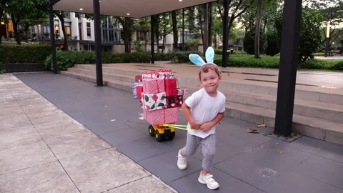 Enthusiastic child pulling cart full of gifts in park Stock Footage 301000553