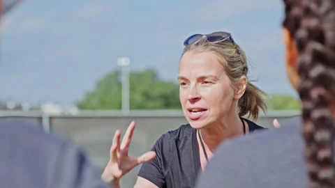 Enthusiastic coach talks with her student athletes on a high school practice 스톡 동영상 305294193