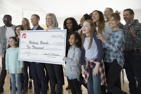 Enthusiastic community posing with large donation check Stock Photos