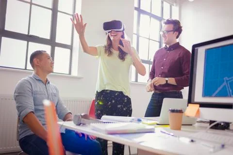 Enthusiastic computer programmers testing virtual reality simulator glasses in Foto stock