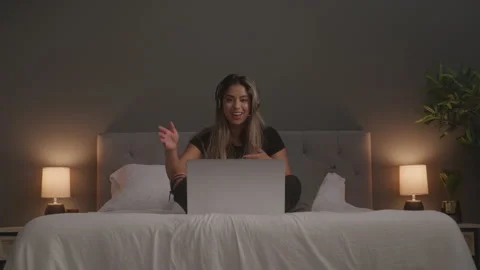 Enthusiastic Female Tech Support Sitting On Bed While Leading Virtual Meeting Stock Footage 208784695