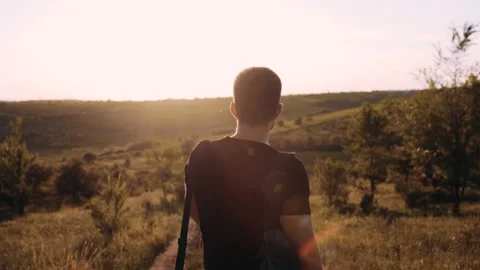 An enthusiastic guy from the sunset, dressed in a black T-shirt and with a rug Stock Footage 135755598