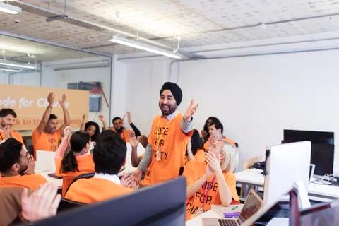 Enthusiastic hackers cheering, coding for charity at hackathon 스톡 사진