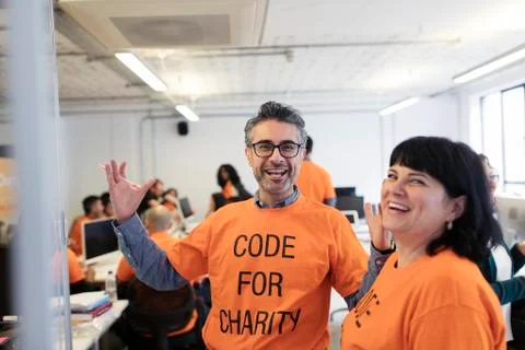 Enthusiastic hackers coding for charity at hackathon Stock Photos
