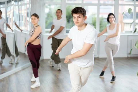 Enthusiastic Hispanic guy energizing group during fitness class Stock Photos