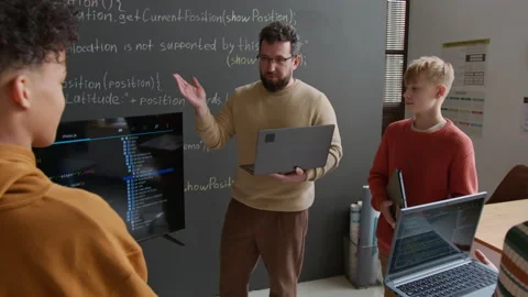 Enthusiastic Male Coding Teacher Demonstrating Script to Students on Screen Stock Footage 318714949
