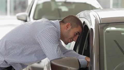 Enthusiastic man exploring a sleek vehicle's interior Stock Footage 311539406