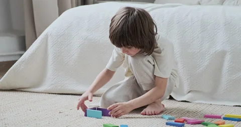 Enthusiastic preschooler confidently constructing multicolored wooden blocks Video stock 163250006