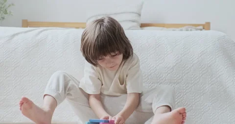 Enthusiastic preschooler confidently constructing multicolored wooden blocks Stock Footage 164970057