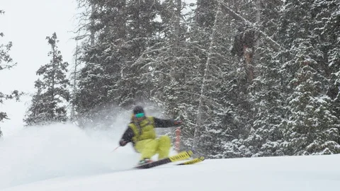 Enthusiastic skier making turns while skiing down the mountain slope speedily Stock Footage 116785916