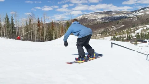Enthusiastic snowboarder performs stunts on snow-covered slope Stock Footage 116786213