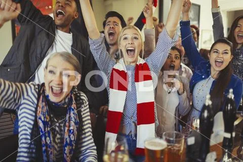 Enthusiastic sports fans cheering watching game in bar Stock Photos
