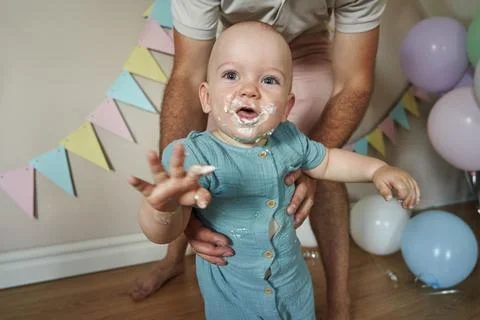 With enthusiastic squeals and clapping, the one-year-old birthday boy gleefully Stock Photos