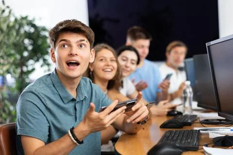 Enthusiastic young guy undergoing training in mobile applications development Stock Photos