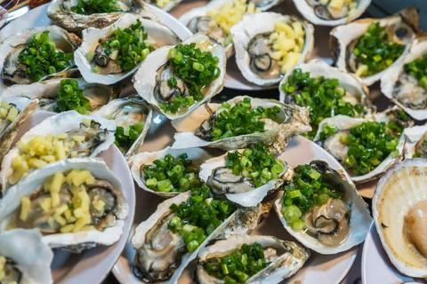 An enticing and visually appealing display of fresh oysters adorned with vibr Foto stock