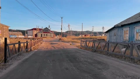 Entrance is along bumpy road to small fishing village in remote northern region Stock Footage 299079046