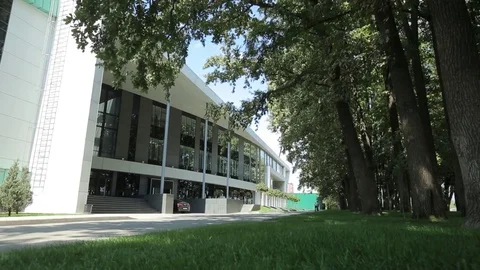 Entrance of the large modern building facing the park zone Stock Footage 75983345