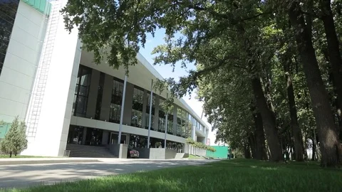 Entrance of the large modern building facing the park zone Stock Footage 75983479