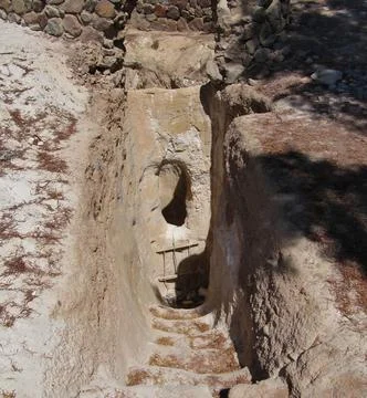 Entrance to a rough water well in a sandy desert in an oasis. Descent with .. Stock Photos