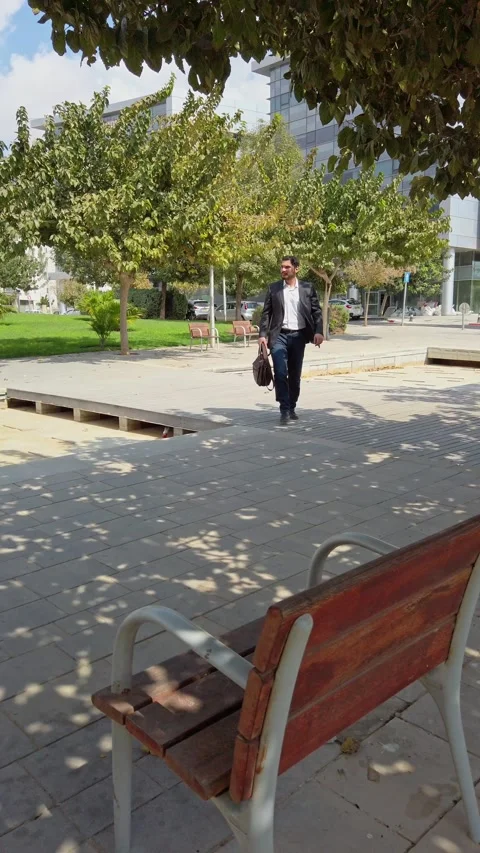 Entrepreneur Approaching Park Seating with Work Bag Stock Footage 324922243
