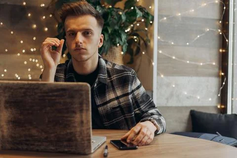 Entrepreneur in checkered shirt thoughtfully while working on laptop Stock Photos