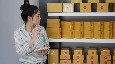 Entrepreneur counting parcel boxes in her own job shopping online business Stock Footage 97485448