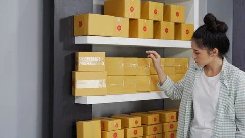 Entrepreneur counting parcel boxes in her own job shopping online business Stock Footage 97486345