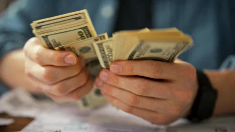 Entrepreneur sits at a table surrounded by financial documents and envelopes Stock Footage 336570701