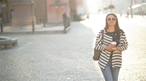 Entrepreneur woman talking on the mobile phone sitting on a bench in the street Stock Footage