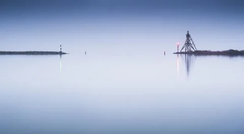 Entry of a harbor in misty conditions Stock Photos