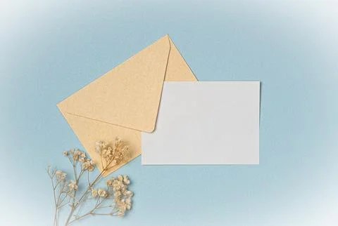 Envelope and empty white paper list with flowers on blue background from abov Stock Photos