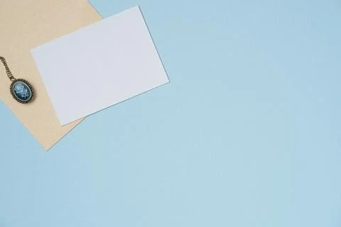 Envelope and empty white paper list with medallion in vintage style on blue.. Stock Photos