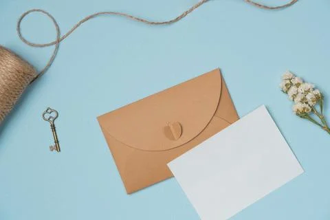 Envelope and empty white paper list with flower, string, key on blue backgr.. Stock Photos
