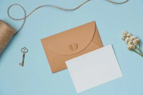 Envelope and empty white paper list with flower, string, key on blue backgr.. Stock Photos