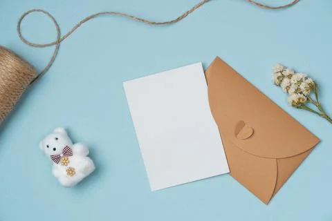 Envelope and empty white paper list with flower, string, key on blue backgrou Stock Photos