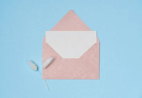 Envelope and empty white paper list with flower on blue background from abo.. Stock Photos