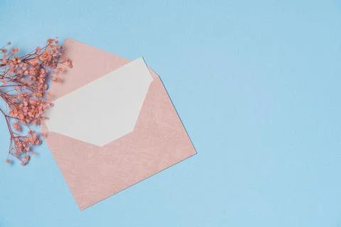 Envelope and empty white paper list with flower on blue background from abo.. Stock Photos