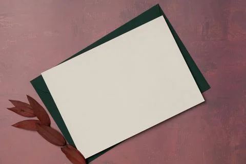 Envelope and empty white paper list on burgundy background from above. Autu.. Stock Photos