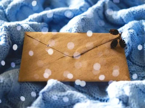 The envelope on the blue wool knitted background with the silver sparkles. Stock Photos