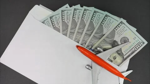 Envelope with dollars next to a flying plane. Savings for trip. Stop motion Stock Footage 293244996