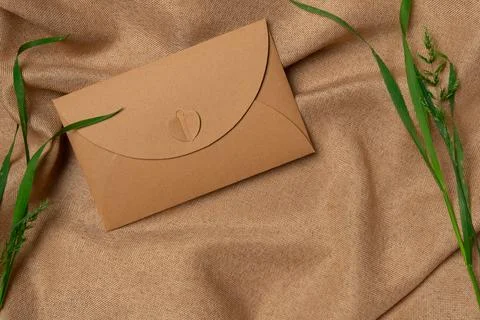 Envelope with grass on a fabric background. Top view, copy space Foto stock