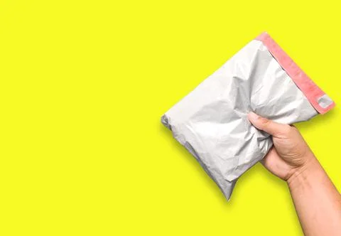 An envelope in the human hand Separate on an intimate yellow background. High Stock Photos