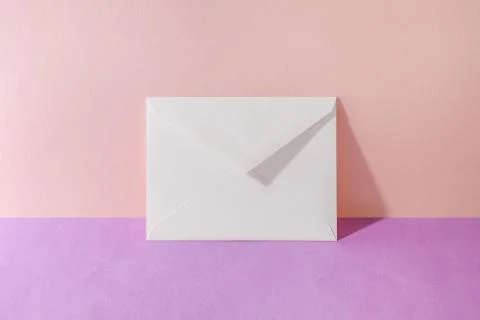 An envelope in a pink two-tone background. Stock Photos